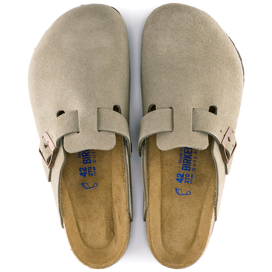 Two tan-colored clogs sit side-by-side. The shoes have a suede upper with a buckle on the side. The footbed has visible markings: 42, 270, and Soft.