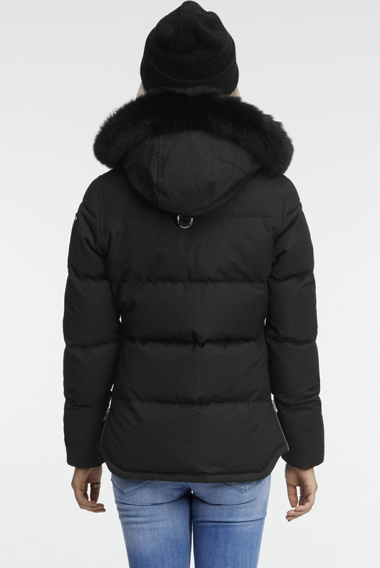 Rear view of a black puffer jacket with a fur-trimmed hood, worn with a black hat.