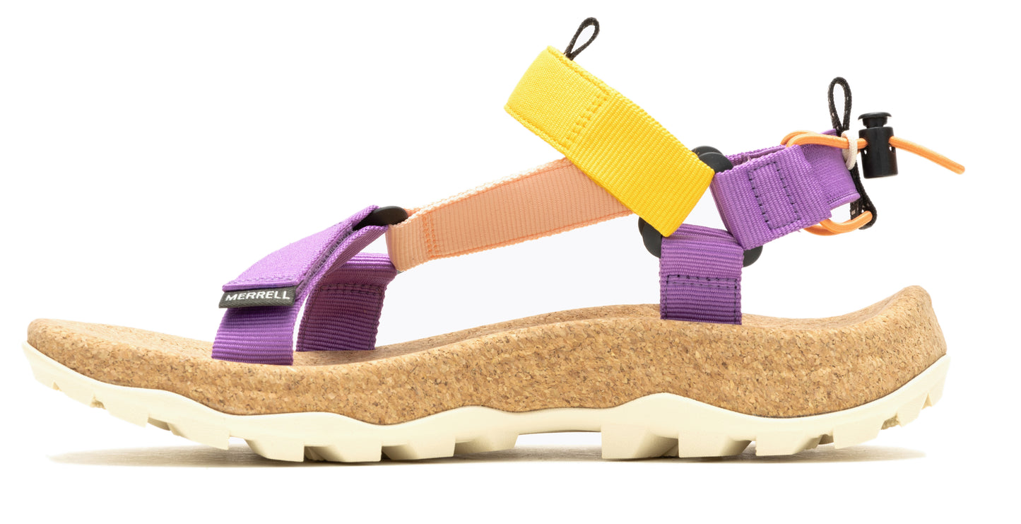 Side view of a sandal featuring a tan cork footbed, a thick white ridged sole, purple, tan, and yellow straps, and a black toggle.
