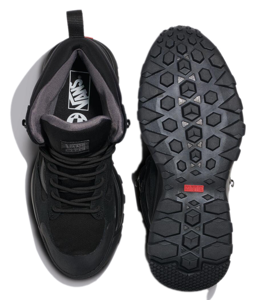 Two black lace-up high-top sneakers, one showing the interior with the word "VANS" and a circular logo, the other showing the patterned sole with a red rectangle.