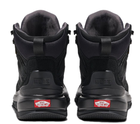 Back view of a pair of black mid-top shoes with 'VANS off the wall' logo visible at the heel.