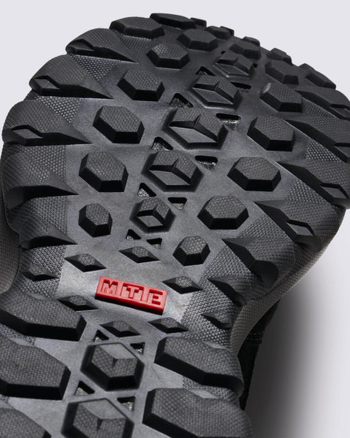 Close-up of a shoe sole showing a complex pattern of rubber treads and an inset rectangle with "MTE".