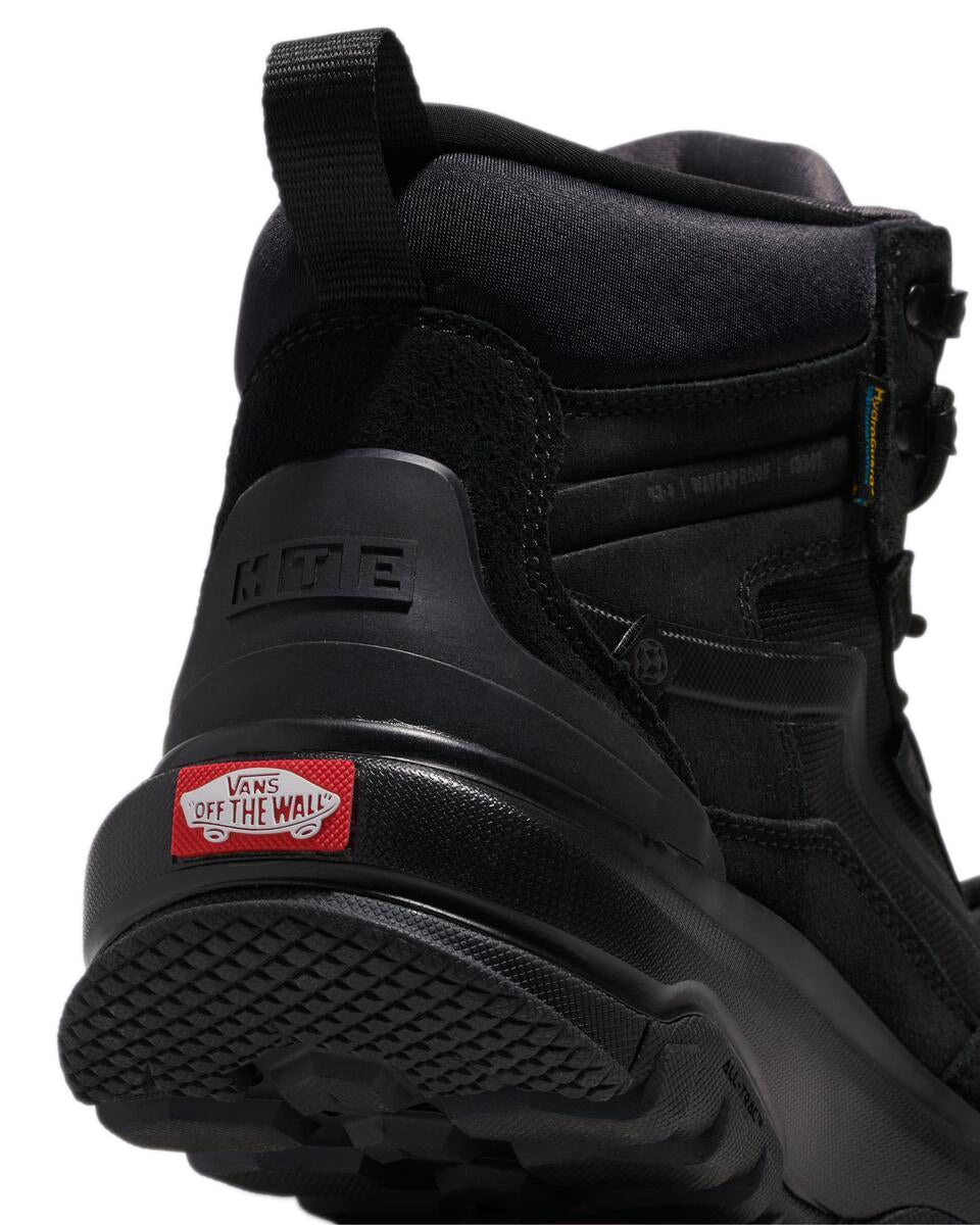 A close-up of the back of a black hiking boot with a red label marked "OFF THE WALL".