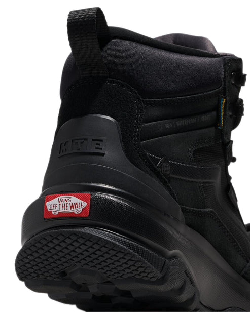 A close-up of the back of a black hiking boot with a red label marked "OFF THE WALL".