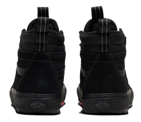 Two black high-top sneakers showing their backs, with black soles and a suede-like upper, each featuring a vertical fabric stripe and a loop at the top of the heel.