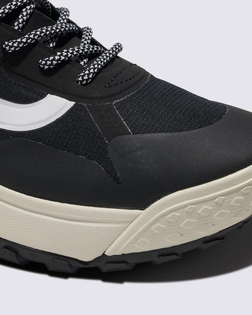 Close-up of a black sneaker featuring a white stripe and patterned laces.