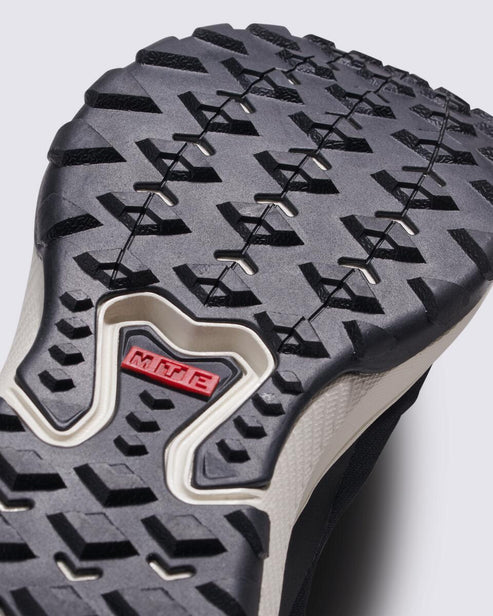 Close up of a black shoe sole with a non-slip grip and white accents. Visible is the red 'MTE' text.
