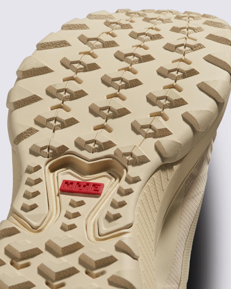 Tan shoe sole with chunky tread and red rectangle in the center.
