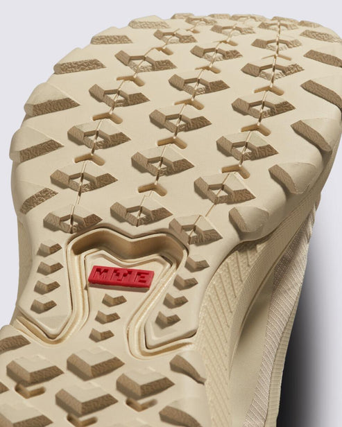 Tan shoe sole with chunky tread and red rectangle in the center.