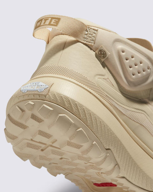 Beige clog style shoe with thick treaded sole and heel pull.