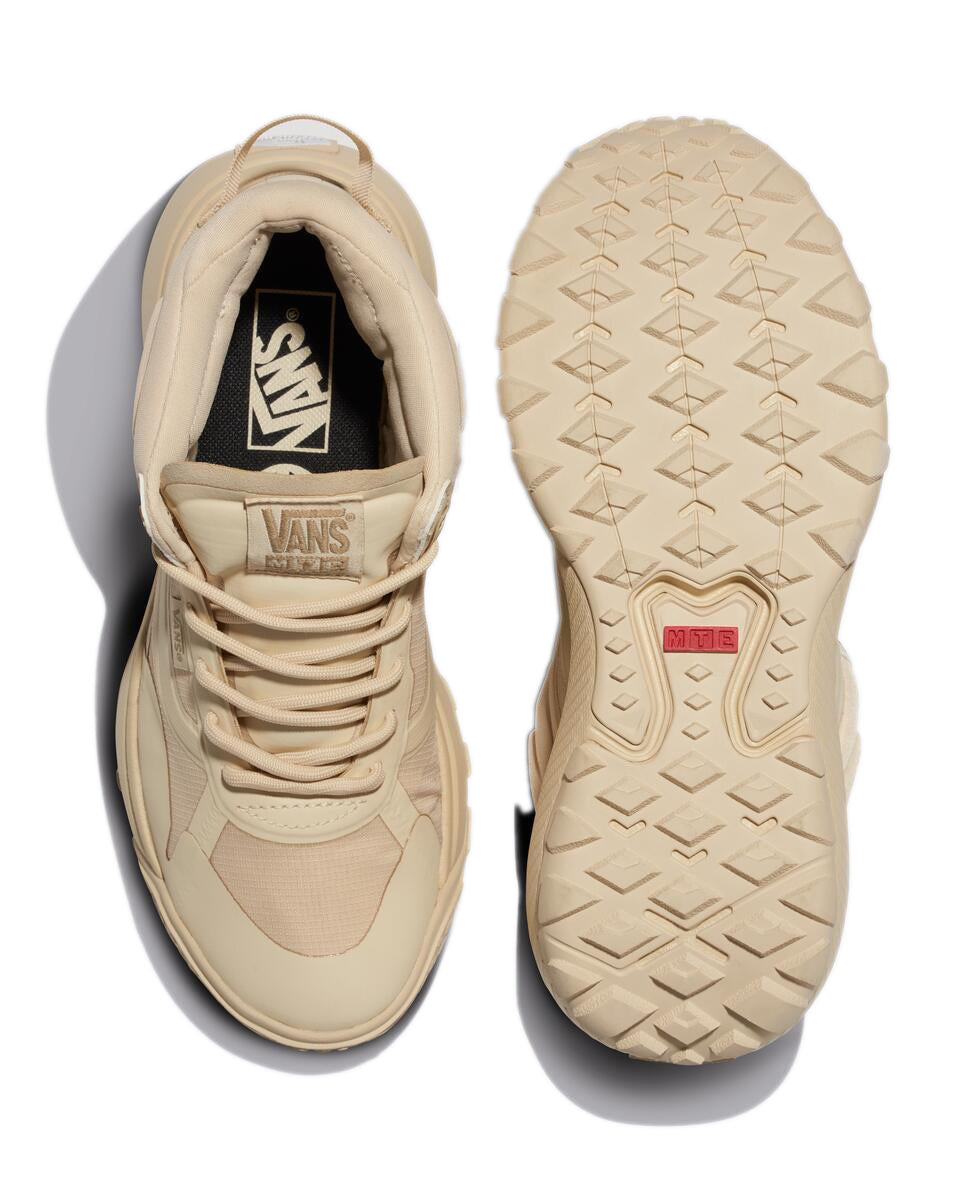 Top-down view of two tan shoes, one upright revealing "VANS" on the insole, the other showing the sole's tread.