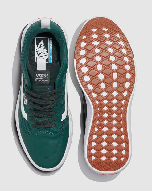 Two green sneakers, one showing the insole, white stripe, and the text "VANS Ultracush", the other showing the brown sole with white lattice pattern.