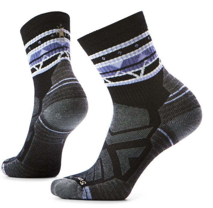 A pair of black socks with a purple and white geometric pattern near the top.