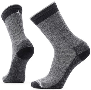 A pair of grey, charcoal, and black wool hiking socks in a mid-calf crew length with ribbed cuffs and a Smartwool logo on the top of the foot.