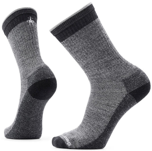 A pair of grey, charcoal, and black wool hiking socks in a mid-calf crew length with ribbed cuffs and a Smartwool logo on the top of the foot.