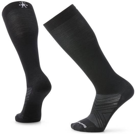A pair of black over-the-calf socks with grey textured arch support patterning and a small white stick figure logo at the top cuff.