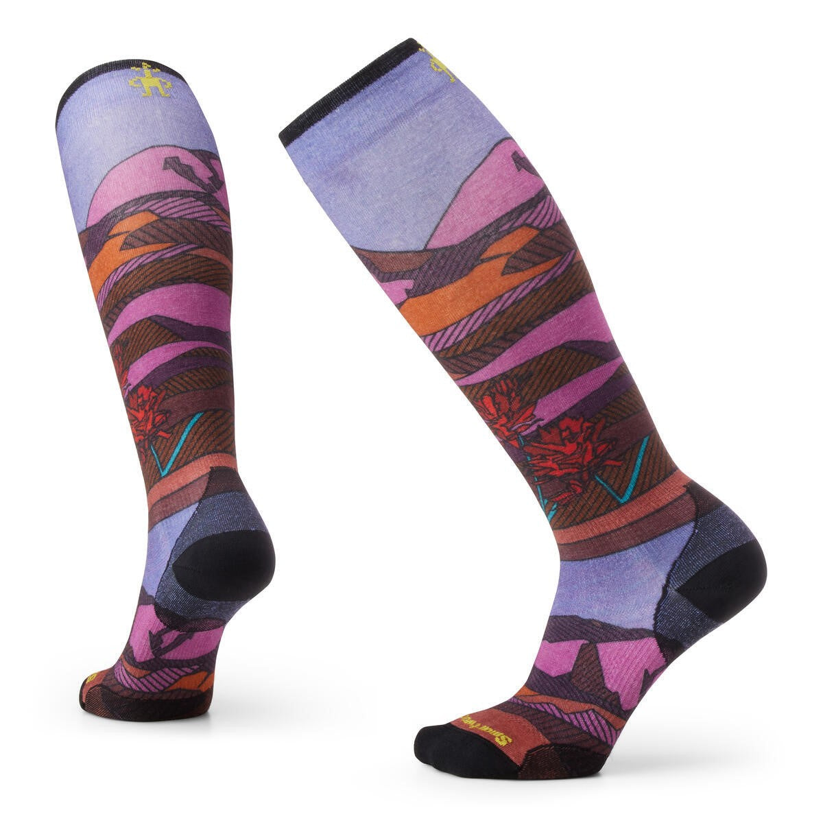 A pair of knee-high socks featuring a printed landscape pattern with stylized mountains in shades of purple, orange, and brown, with black heels, toes, and cuffs.