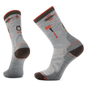 Two gray socks with an axe, fishing spear, and horse shoe pattern and brown heel, toe, and cuff.
