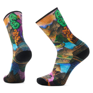 Two colorful crew socks with a mountain scene pattern and black toes and cuffs.
