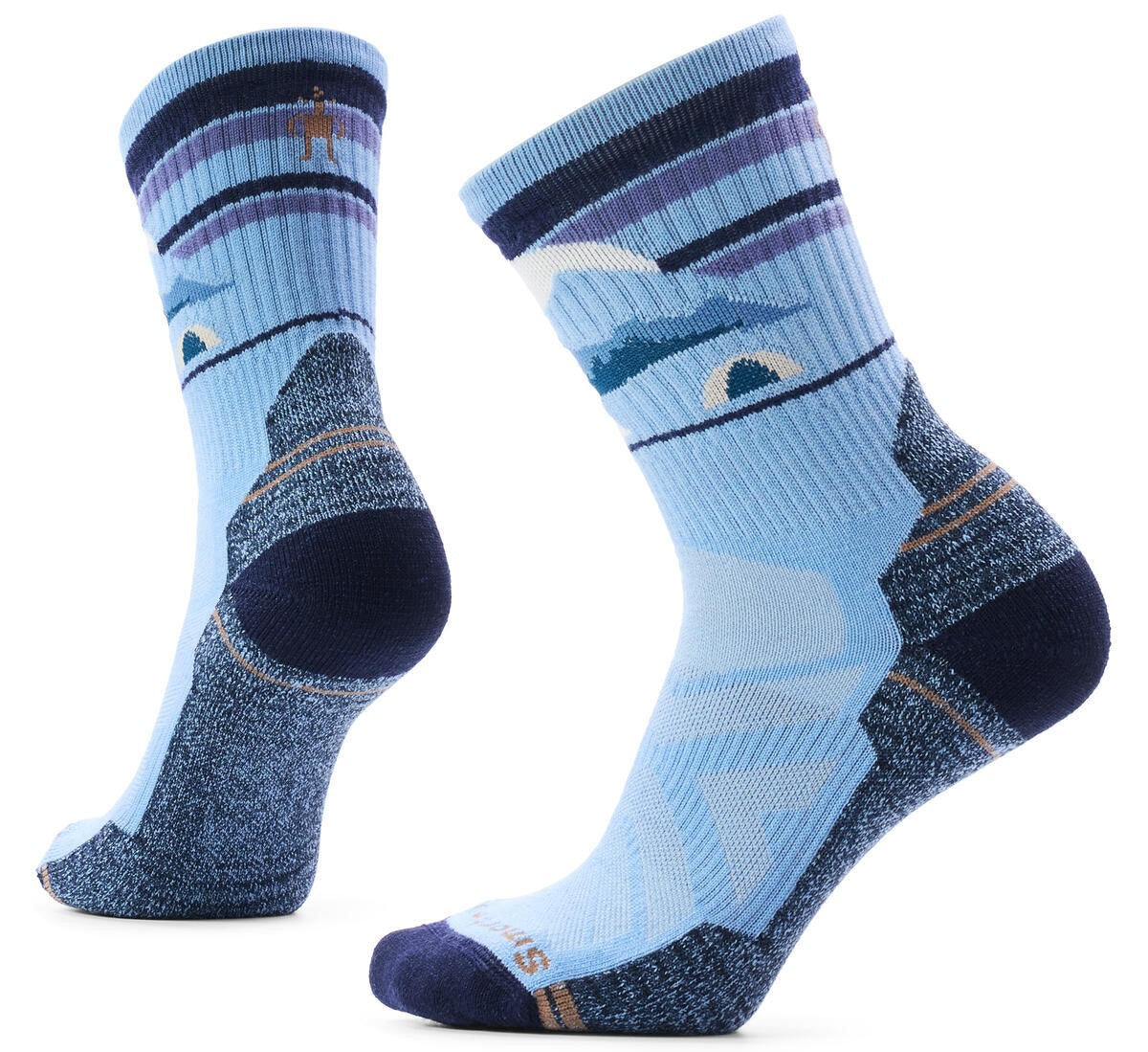 A pair of crew-length hiking socks in shades of light and dark blue, featuring a knit pattern of mountains and a small tent on the upper leg, with dark blue reinforced heels and toes.