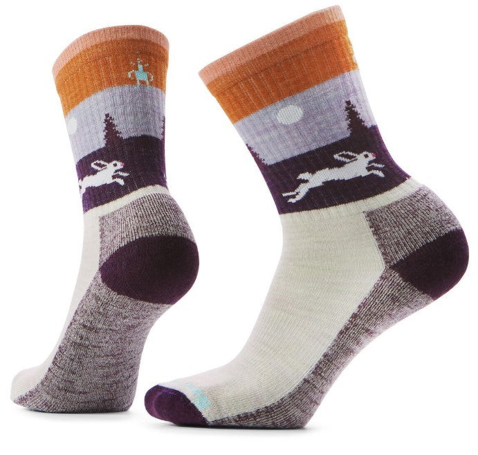 Pair of cushioned crew socks, white foot with gray heel, purple arch support, and a colorful scene of a rabbit running in a purple landscape with a sun and a person on horseback on the cuff.