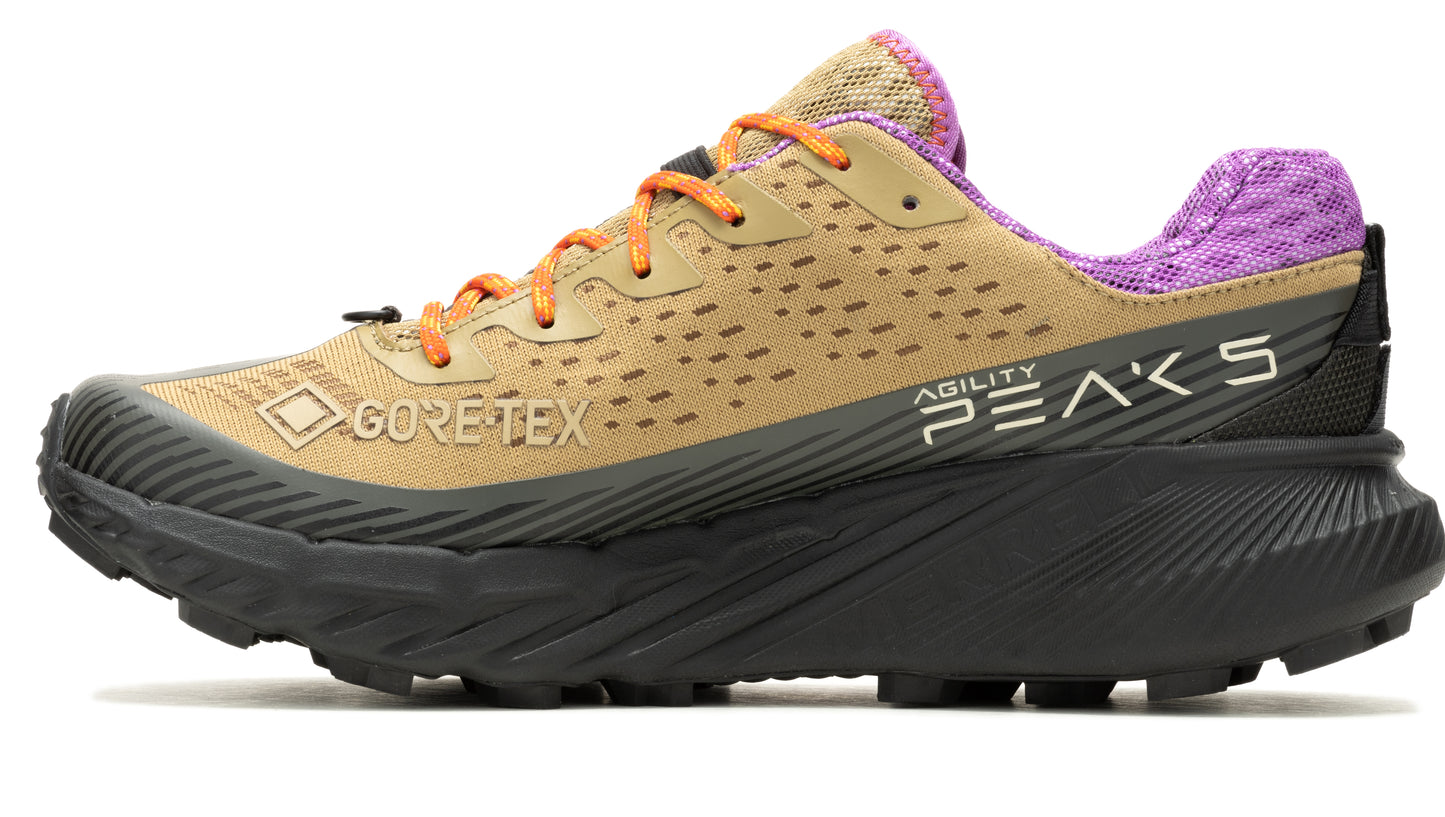 Trail running shoe: tan upper with orange laces, black sole, and a purple heel. "GORE-TEX" and "Agility Peaks" text are on the side.