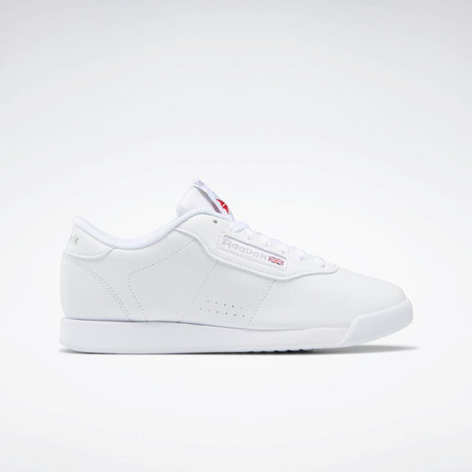 A white tennis shoe with a flat sole and 'Reebok' logo on the side.