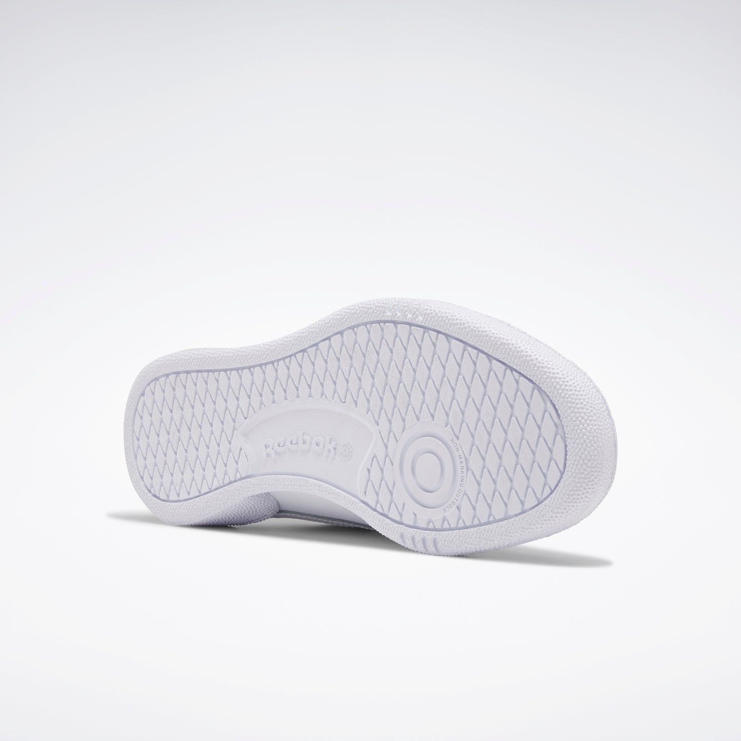 White shoe sole featuring a circular pattern and "Reebok" text.