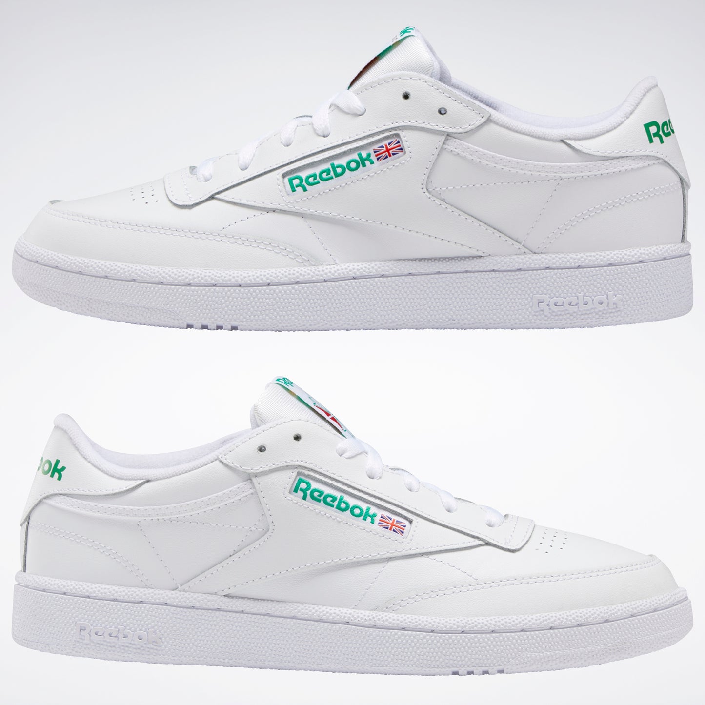 Two Reebok white leather shoes with green logo on the side and the heel.
