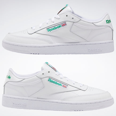 Two Reebok white leather shoes with green logo on the side and the heel.