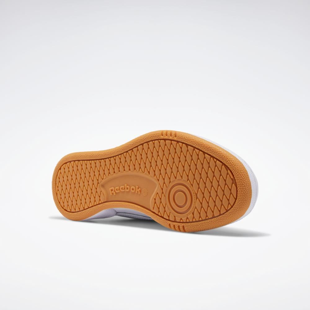 Close up of shoe sole in brown with honeycomb texture, showing the name "Reebok" in the center.
