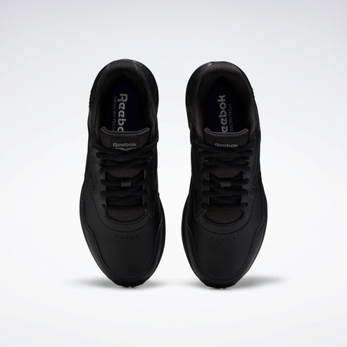 A pair of all-black sneakers with black laces and a rounded toe.