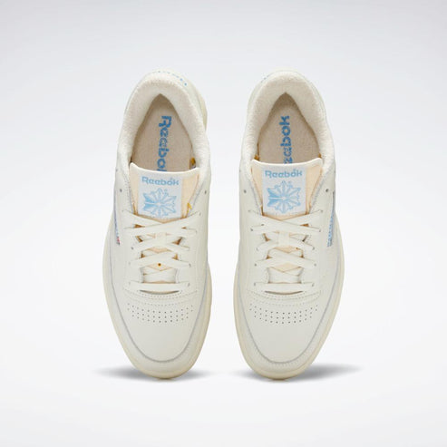 Front view of two ivory sneakers with light blue logos on the tongue and inner lining.