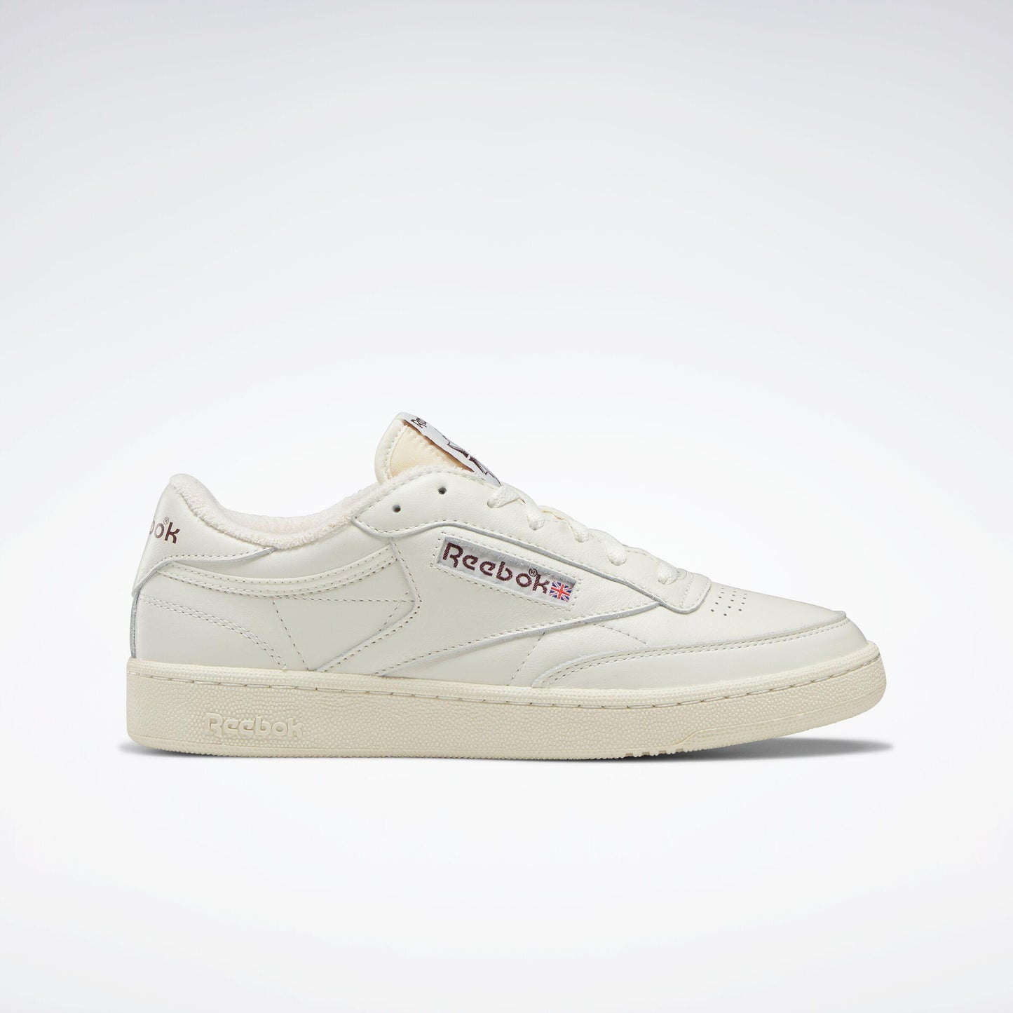 Off-white leather sneaker with the text "Reebok" on the side and perforations at the toe box.