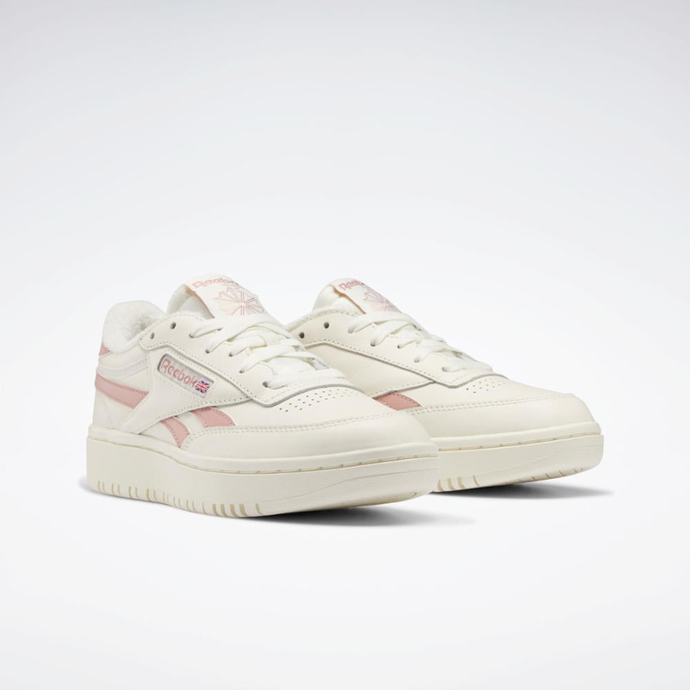 Pair of off-white sneakers with pink stripes.