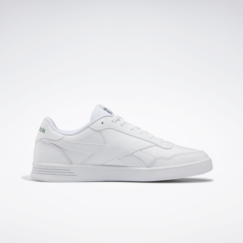 A white sneaker with a flat rubber sole and a stylized side logo.