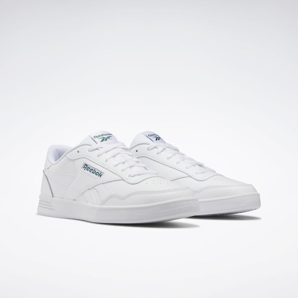 Two white sneakers with green lettering.