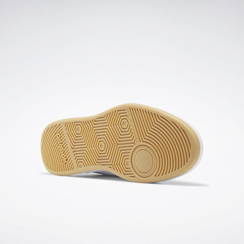 The bottom of a light tan shoe shows concentric circles at the heel, hexagonal pattern on the forefoot, and the word "REEBOK".