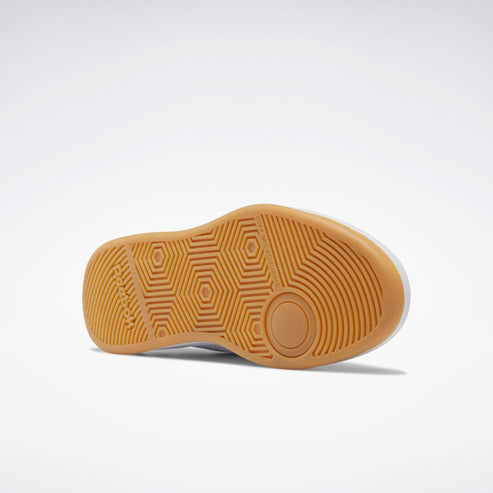 Close-up of the bottom of a shoe with a tan rubber sole with a hexagonal pattern.