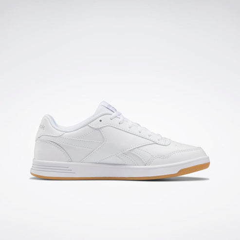 A low-top, all-white sneaker with white laces and a gum sole.