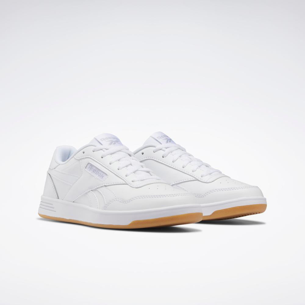 Low-top white sneaker with a gum sole and printed text on the upper.