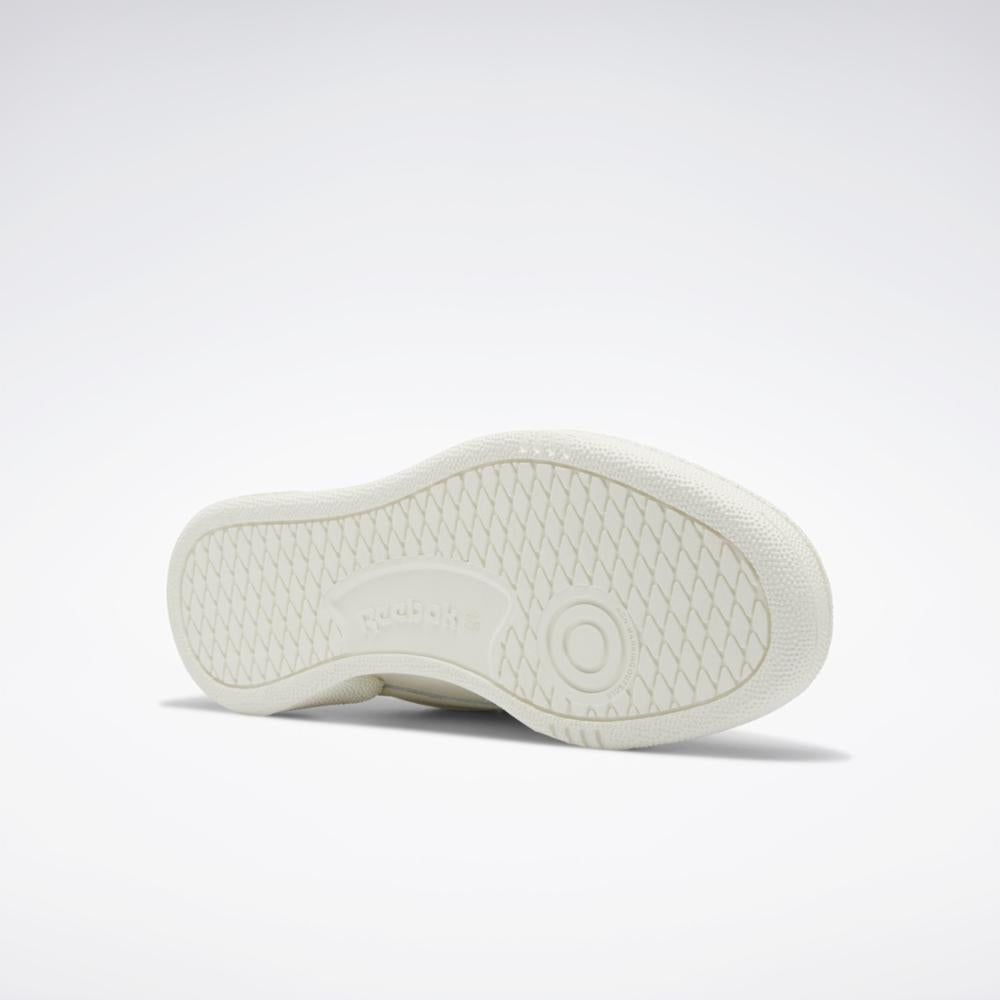 The off-white outsole of a shoe with a textured pattern and circular pivot point.