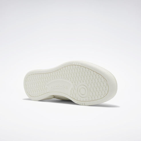 The off-white outsole of a shoe with a textured pattern and circular pivot point.