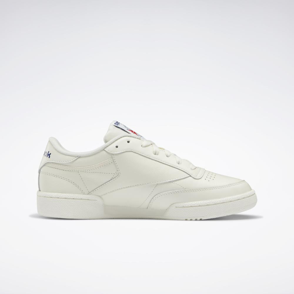Off-white leather sneaker with blue logo on the heel and tongue.