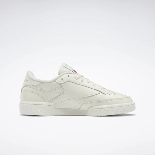 Off-white leather tennis shoe with red logo.