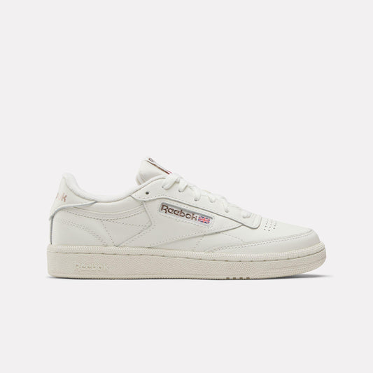 Low-profile off-white sneaker with pink and red logo.