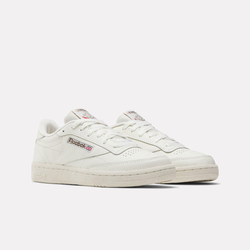 Off-white leather low-top sneakers with perforated toe box, and logo detail.