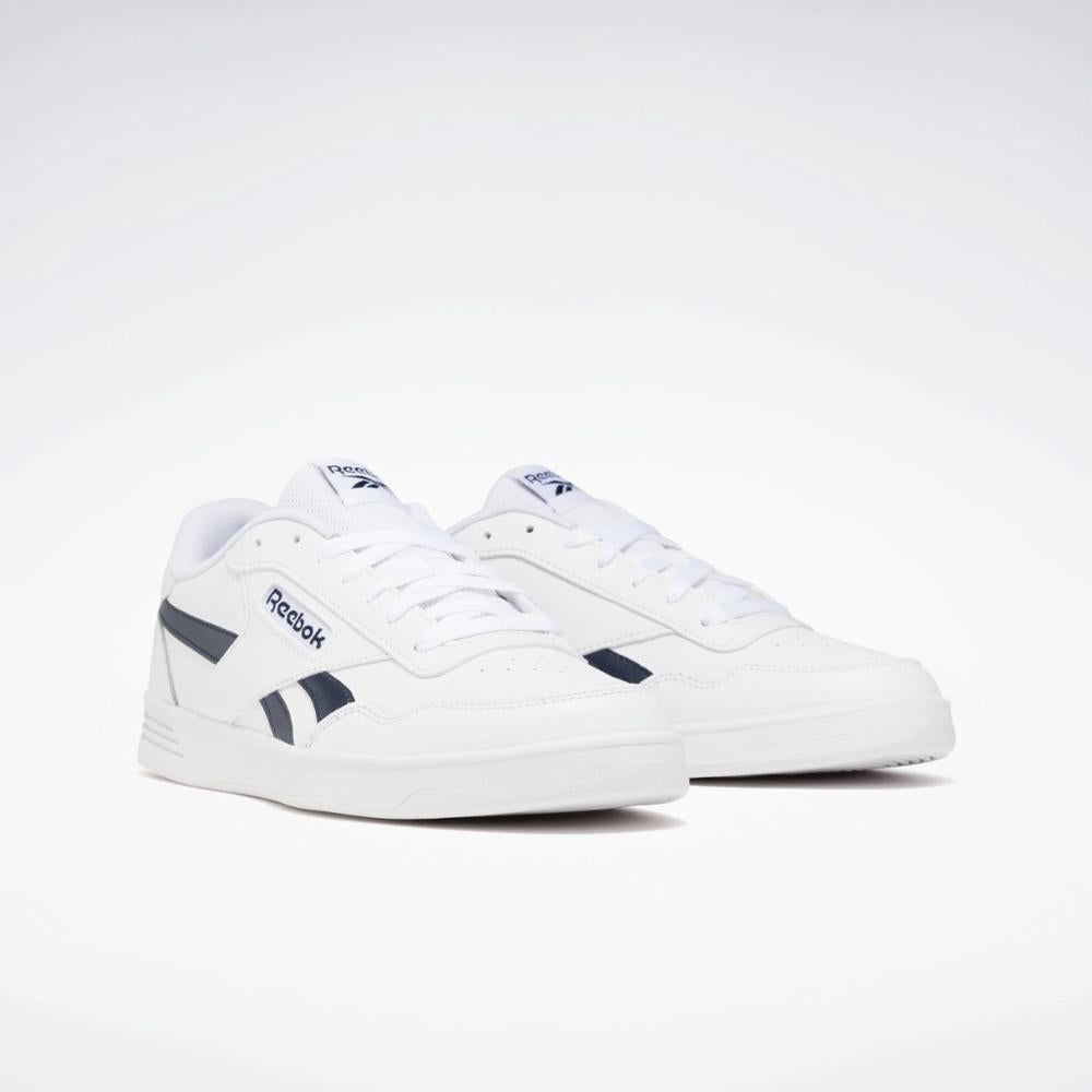 White sneakers with dark blue logo on the side and tongue.