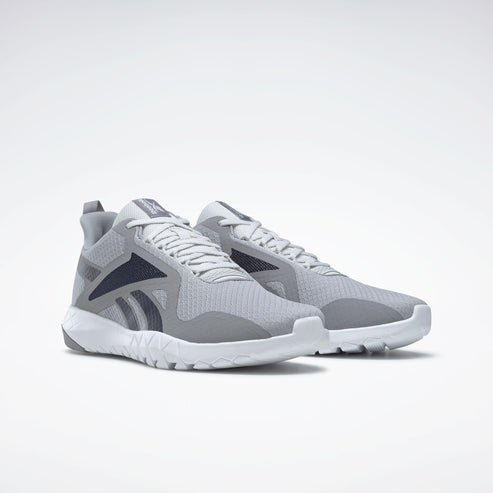 A pair of light gray athletic shoes with white soles and dark blue accents on the side.