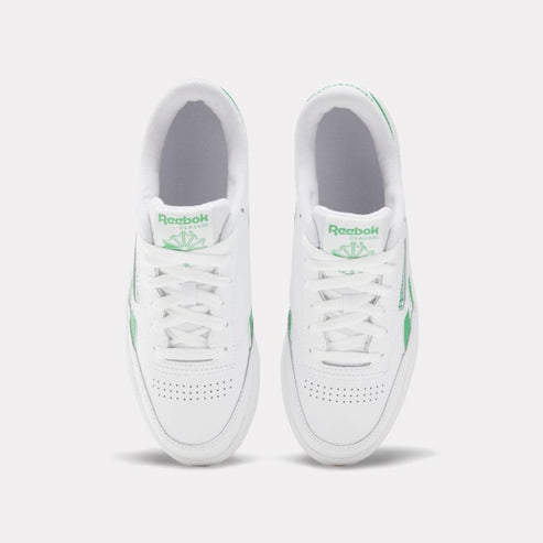 Two white sneakers with green accents and white laces.